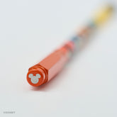 A close-up of a Blackwing red pencil point guard featuring a silver Mickey Mouse silhouette, shown on a clean white background with the rest of the pencil blurred due to a shallow depth of field.