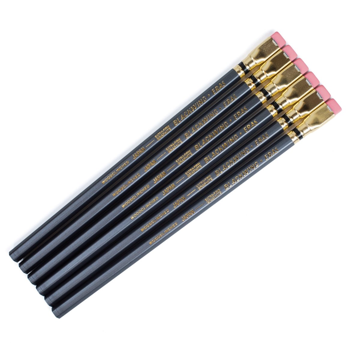 Six dark grey pencils with gold lettering and pink erasers, arranged diagonally on a plain white background.