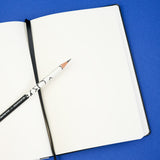 Open notebook with a pencil on a blue background