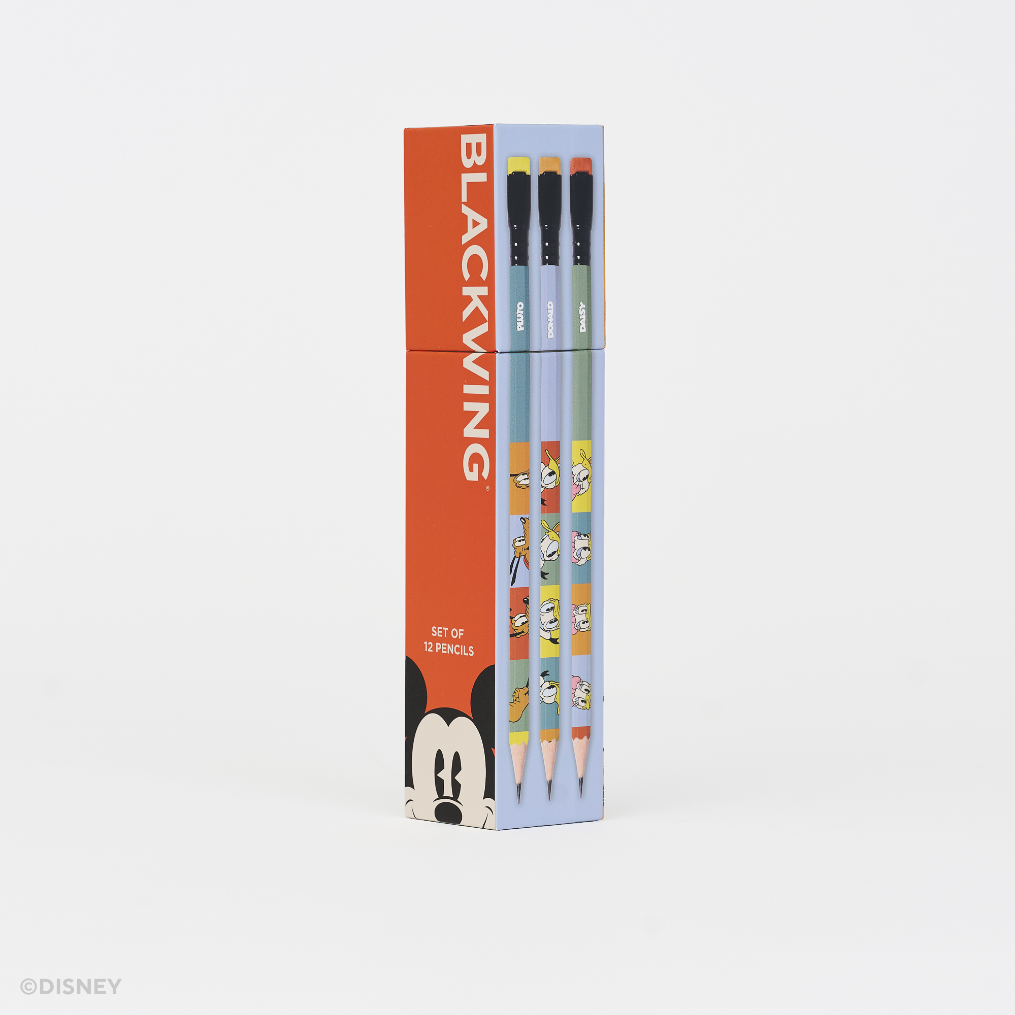 A boxed set of pencils standing upright on a clean white background. The packaging is bright red on the left with the word BLACKWING in large white letters and a Mickey Mouse face at the bottom, while the right side is light blue and shows the pencil barrels with cartoon graphics.