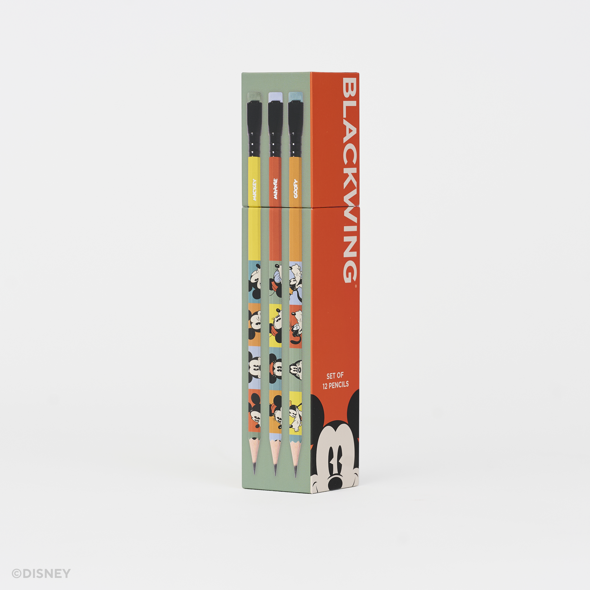 A boxed set of Disney Blackwing pencils standing upright on a clean white background. The packaging is mint green and bright orange-red, with printed character illustrations and the word BLACKWING prominently visible.