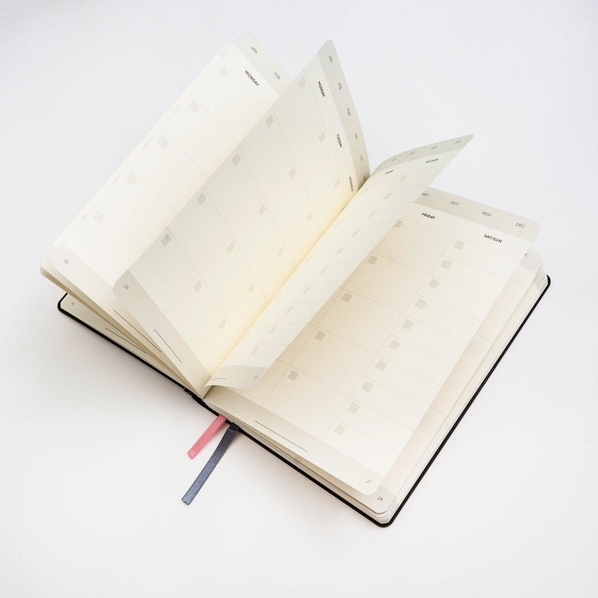Blackwing Planner open with a fan of blank monthly view pages showing against a white background.