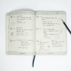 Open Blackwing Planner showing a filled-in weekly spread with handwritten notes and small illustrations across the pages against a white background.