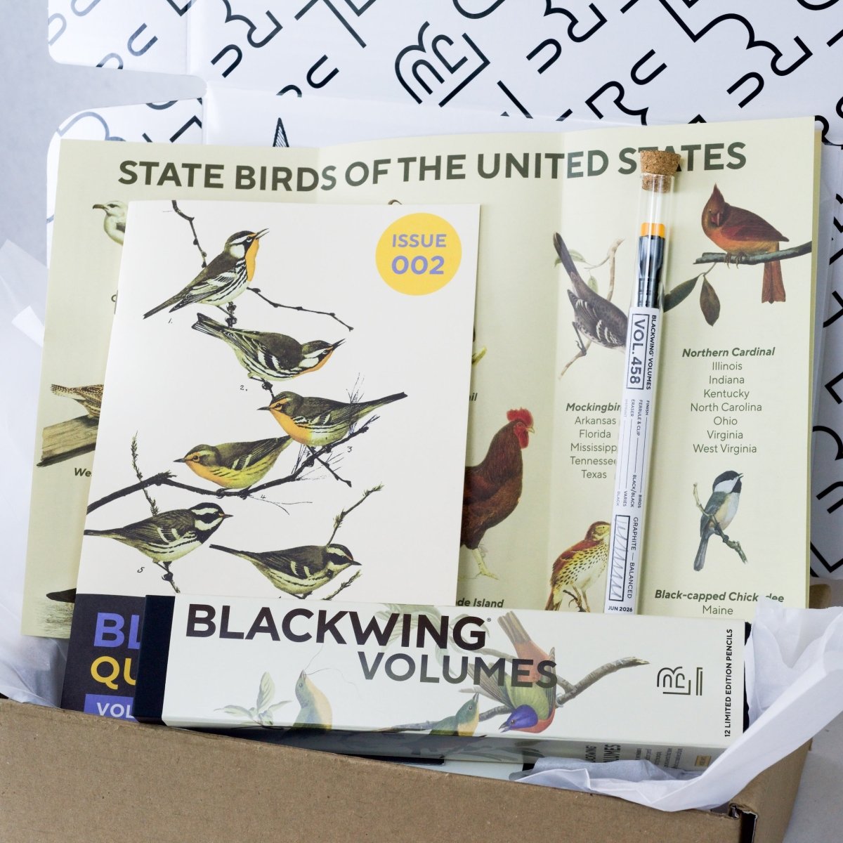 Blackwing Vol. 458 Subscription Box open showing the contents which includes a box of Vol. 458 pencils, Issue 002 of the zine, State Bird Map, and archive pencil. All have illustrations of various birds.