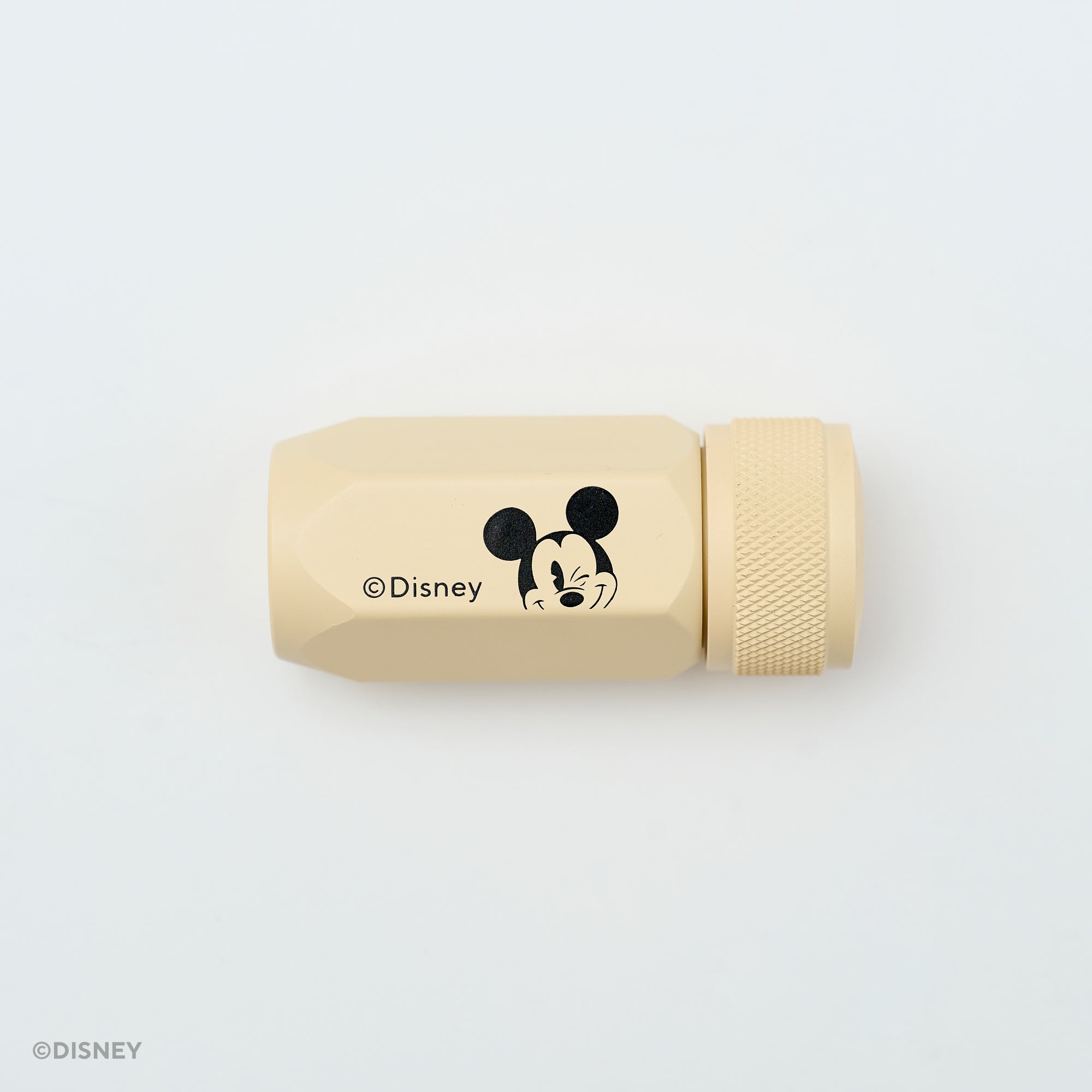 A beige Disney sharpener with a black Mickey Mouse face graphic and the Disney copyright text, shown on a clean white background.