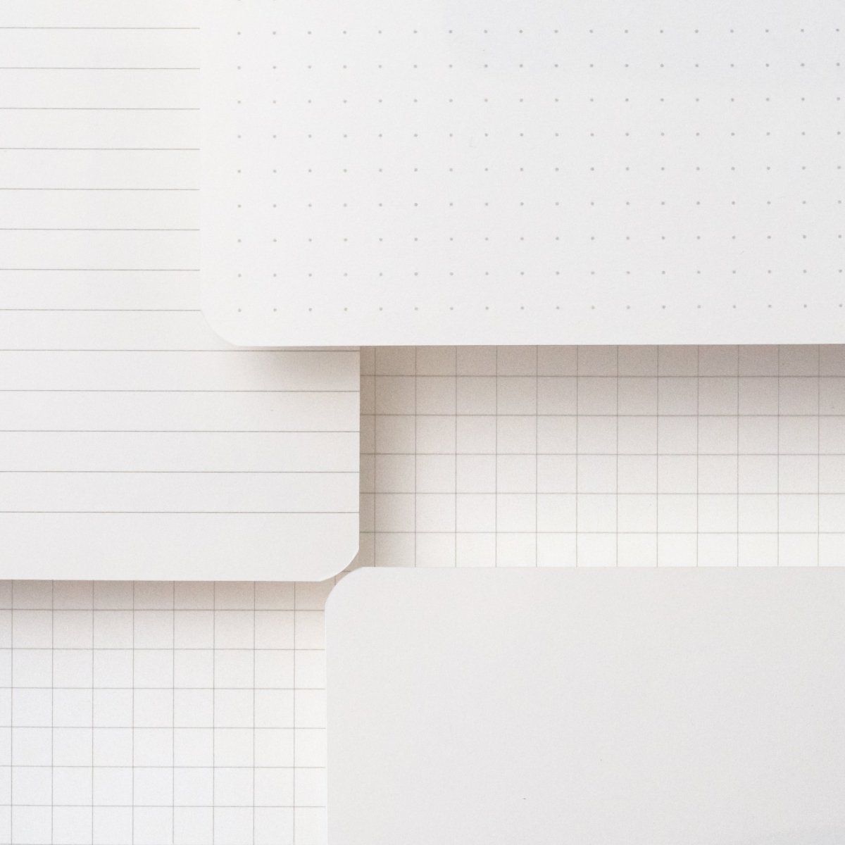 Blackwing Slate Notebooks displaying paper types: dot-grid, ruled, grid, and blank